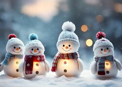Cztery oświetlone bałwanki na śniegu