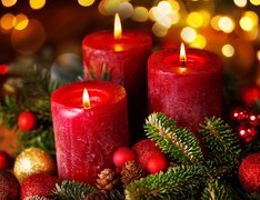 Dekoracja świąteczna z czerwonymi świecami otoczonymi gałazkami
