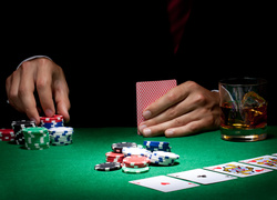 Dłonie mężczyzny obstawiającego stawkę w pokerze
