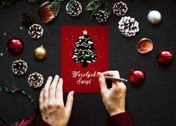 Dłonie na kartce z życzeniami świątecznymi