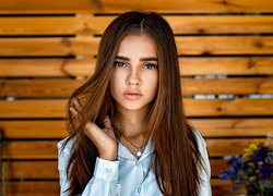 Długowłosa dziewczyna z kwiatami w tle