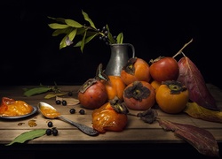 Dojrzałe owoce persymony, łyżeczka i dzbanek położone na deskach