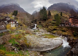 Dolina Valle Verzasca w Szwajcarii z wodospadem i domami na wzgórzu
