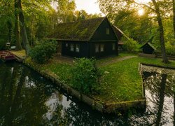 Dom i zielone drzewa nad kanałem