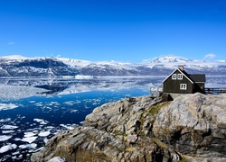 Dom na skale w Grenlandii otoczony górska rzeką