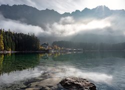 Dom nad jeziorem Eibsee w zamglonych Alpach Bawarskich