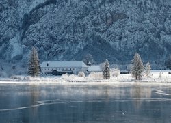 Dom nad jeziorem w górach zimą