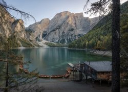 Domek drewniany i łódki nad jeziorem Pragser Wildsee