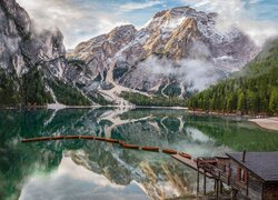 Domek i łódki na jeziorze Pragser Wildsee z widokiem na włoskie Dolomity