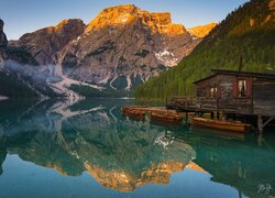 Domek i łódki przy pomoście na jeziorze Lago di Braies oraz Dolomity