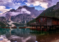 Domek na pomoście i łodzie na jeziorze Lago di Braies we Włoszech