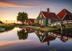 Domki i wiatrak nad kanałem w skansenie Zaanse Schans w Holandii