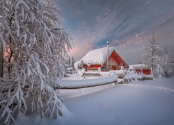 Domki w zimowym krajobrazie o zmierzchu