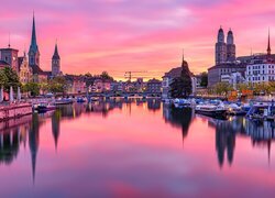 Domy i łodzie na rzece Limmat w Zurychu pod kolorowym niebem