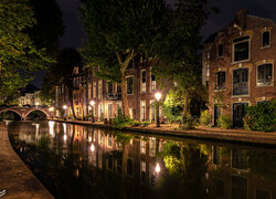 Domy i zaświecone latarnie nad kanałem w holenerskim mieście Utrecht