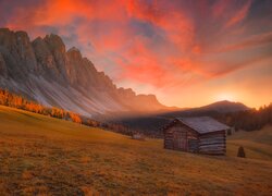 Drewniana szopa na płaskowyżu Seiser Alm w Dolomitach pod kolorowym niebem