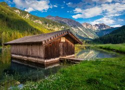 Drewniana szopa nad górskim jeziorem w Austrii