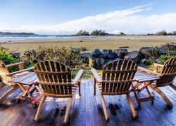 Drewniane krzesła na pomoście z widokiem na plażę Chesterman Beach w Kanadzie