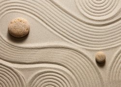 Dwa kamienie i linie na piasku