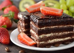 Dwa kawałki ciasta w czekoladzie z truskawkami
