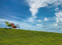 Dwa krzesła na trawiastym wzgórzu