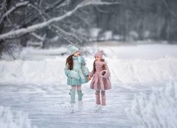 Dwie dziewczynki na lodowisku wśród drzew