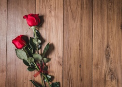 Dwie róże na deskach przewiązane wstążką