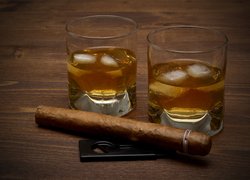 Dwie szklanki whisky z lodem i cygaro