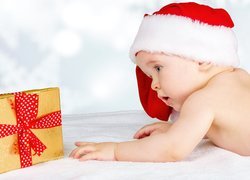 Dziecko w czapce Mikołaja i prezent
