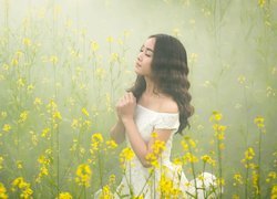 Dziewczyna pośród żółtych kwiatów we mgle
