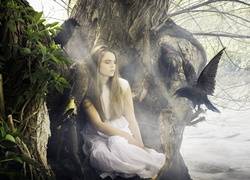 Dziewczyna siedząca na drzewie i krążące przy niej kruki