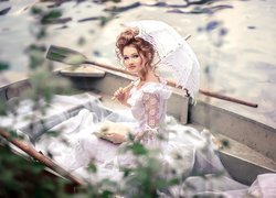 Dziewczyna w koronkowej sukience na łódce
