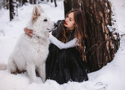 Dziewczyna z białym psem w lesie