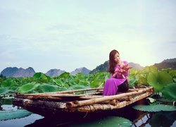 Dziewczyna z bukietem kwiatów na łódce