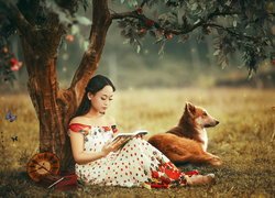 Dziewczyna z książką i psem pod drzewem