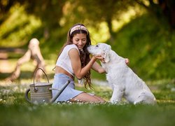 Dziewczyna ze szczeniakiem golden retrievera na łące