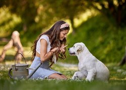 Dziewczyna ze szczeniakiem golden retrievera na trawie