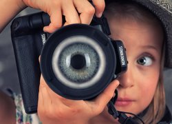 Dziewczynka i oko w obiektywie aparatu fotograficznego