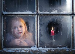Dziewczynka i świeca w oknie