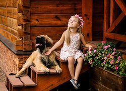 Dziewczynka i szczeniak leonbergera siedzą na schodach