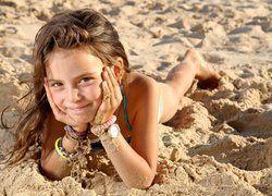Dziewczynka leżąca na piasku