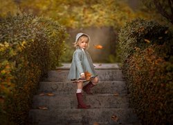 Dziewczynka na schodach przy żywopłocie