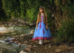 Dziewczynka pod drzewami na brzegu rzeki