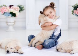 Dziewczynka przytulająca szczeniaka golden retrievera