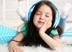 Dziewczynka słuchająca muzyki na słuchawkach