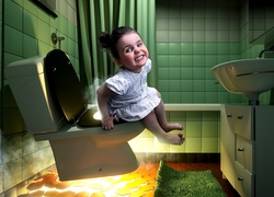 Dziewczynka w łazience na podświetlonym sedesie