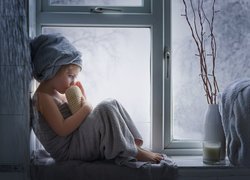 Dziewczynka w ręczniku przy oknie
