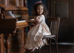 Dziewczynka w sukience przy pianinie