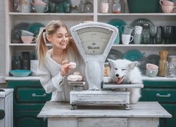 Dziewczynka z białym lisem obok wagi sklepowej