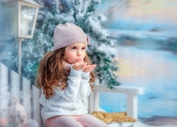 Dziewczynka z gracją rozdmuchuje płatki śniegu